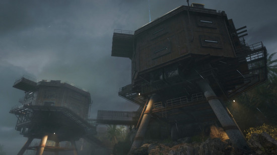 A gloomy scene showing two industrial buildings in Terminus, one of the Black Ops 6 Zombies maps.