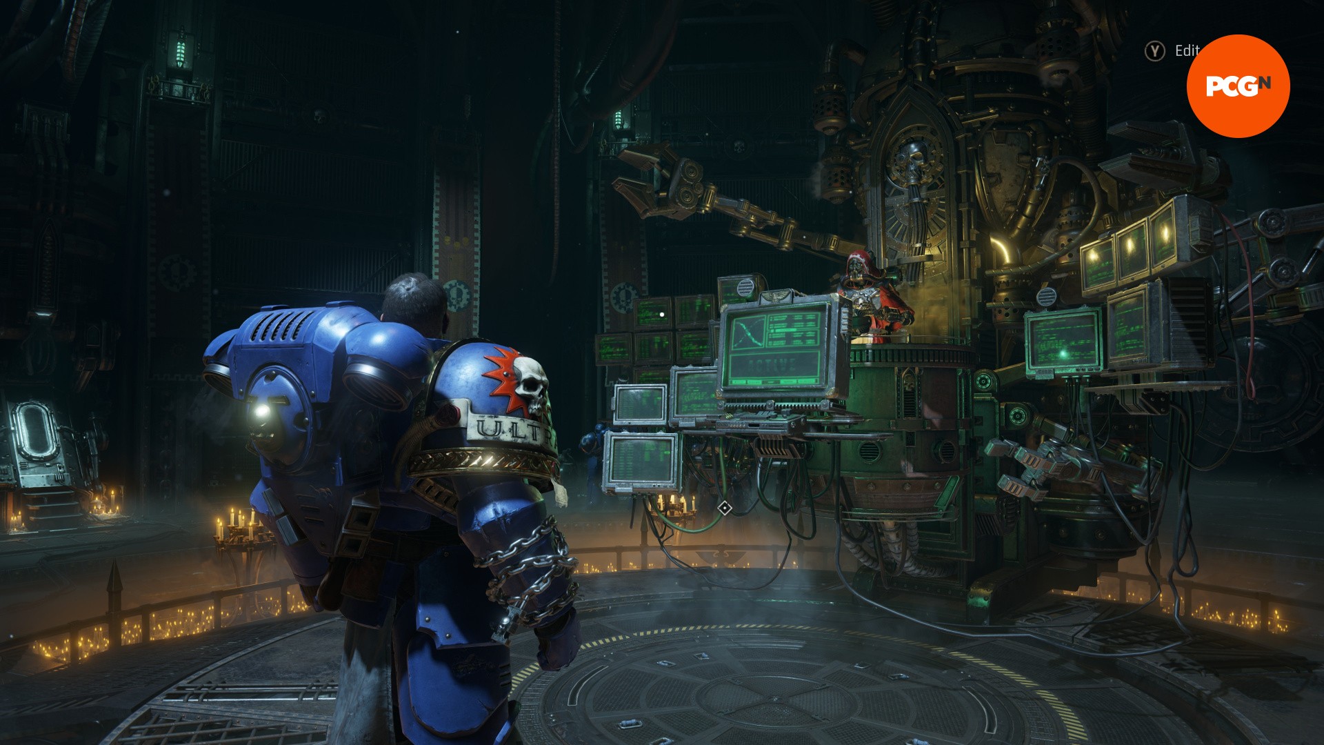 Space Marine 2 review: A man in blue armor stands in front of computer terminals, from Space Marine 2.