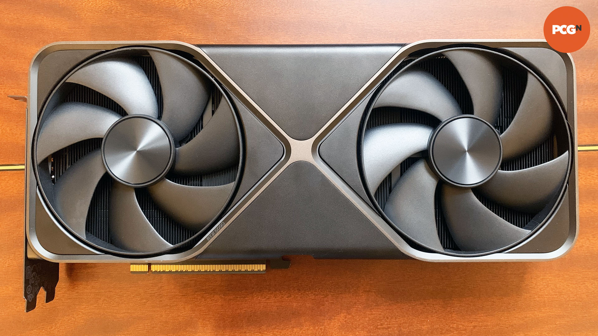 Nvidia GeForce RTX 5090 review: Front of graphics card showing fans on wood background.